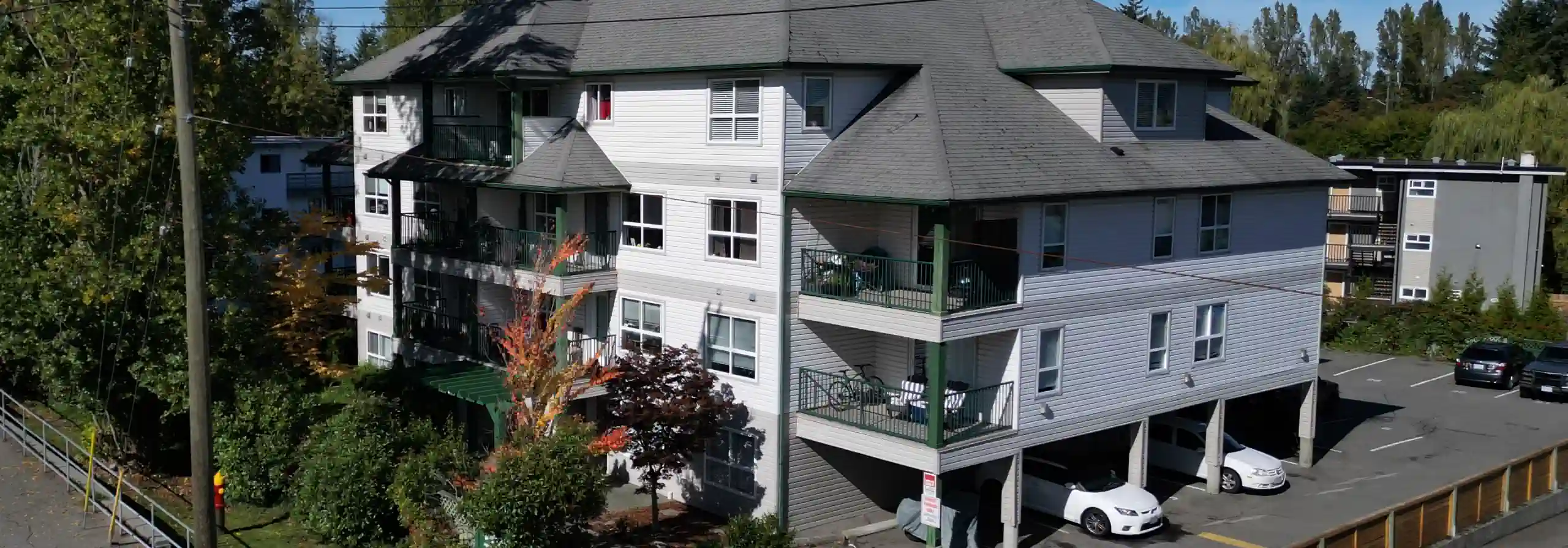 Photo of a 4-storey 1990s condo building with carports beneath